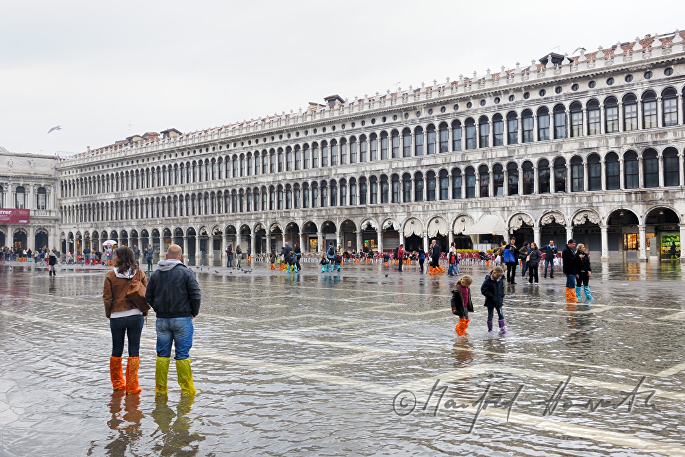 family crossing Piazza San Marco during Acqua alta