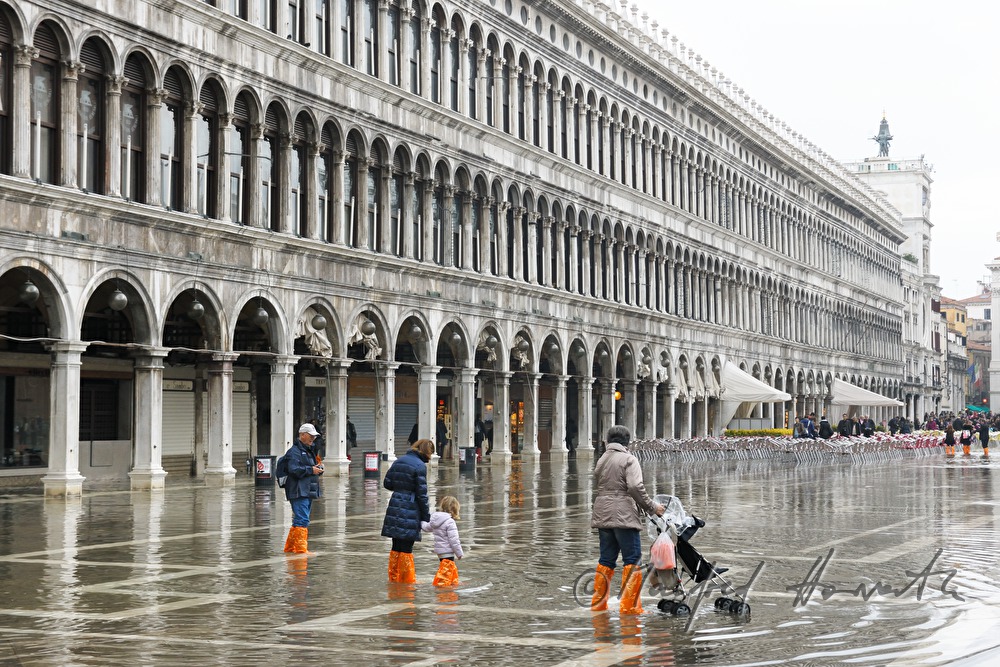 family crossing Piazza San Marco during Acqua alta