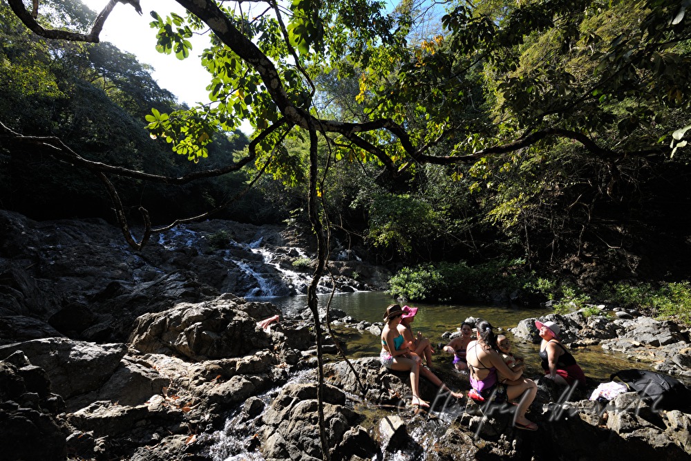 family chills off in the river near the waterfall Montezuma