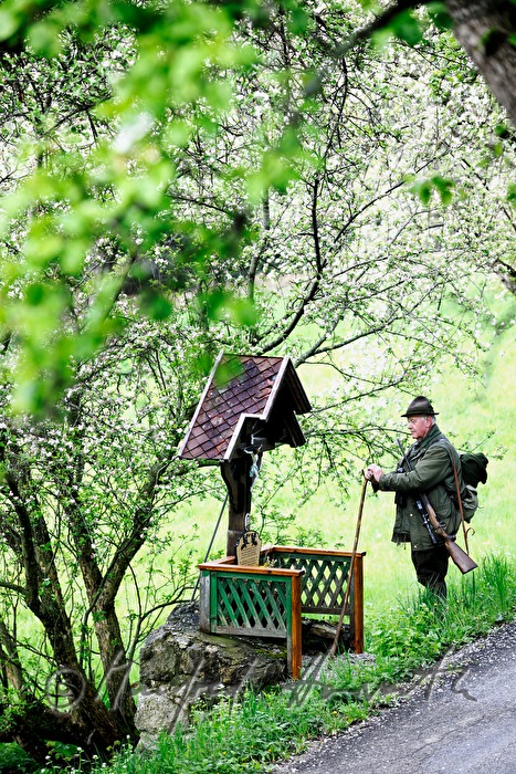 gamekeeper meditates at a wayside shrine