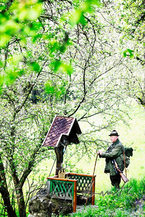 gamekeeper meditates at a wayside shrine