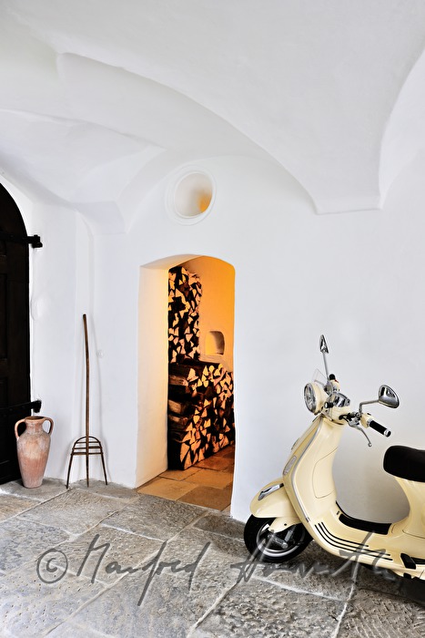 doorway with motor  scooter and wood store