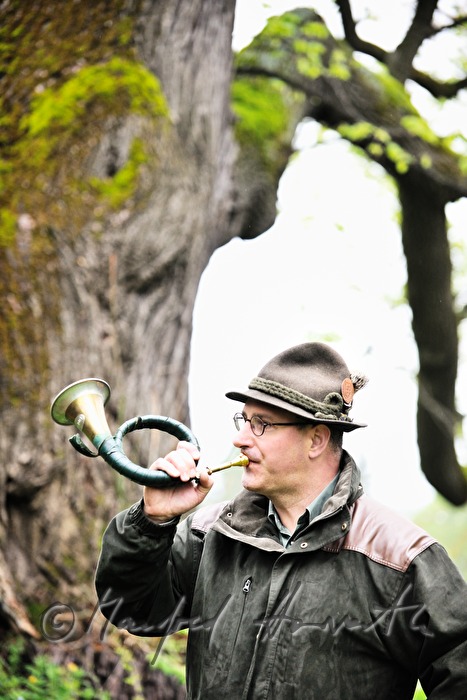 gamekeeper with a bugle blowing