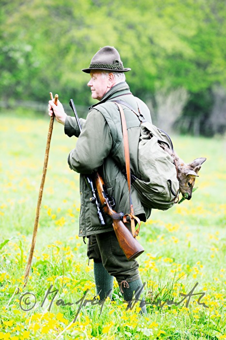 gamekeeper with newly hunted deer in the knapsack