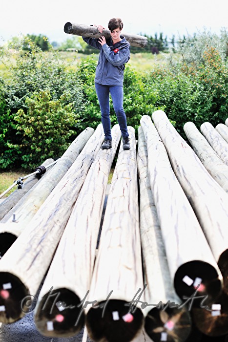 woman electrician carrying a power pole