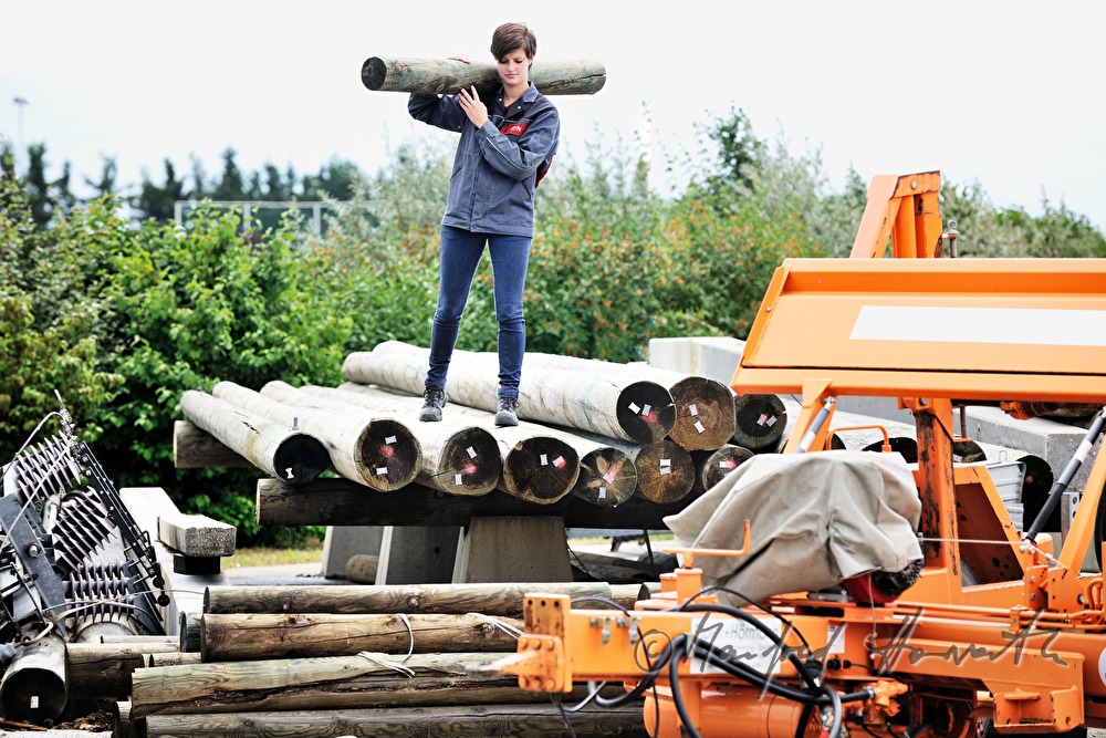 woman electrician carrying a power pole