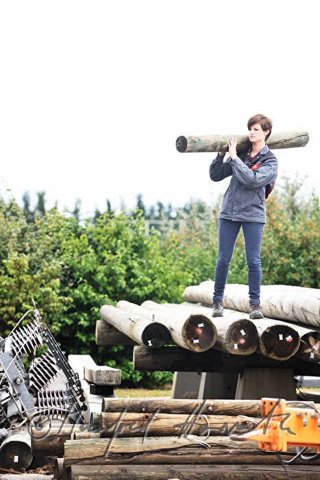 woman electrician carrying a power pole