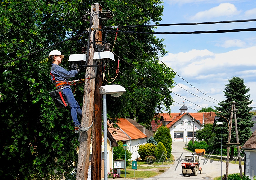 woman electrician climbing a power pole