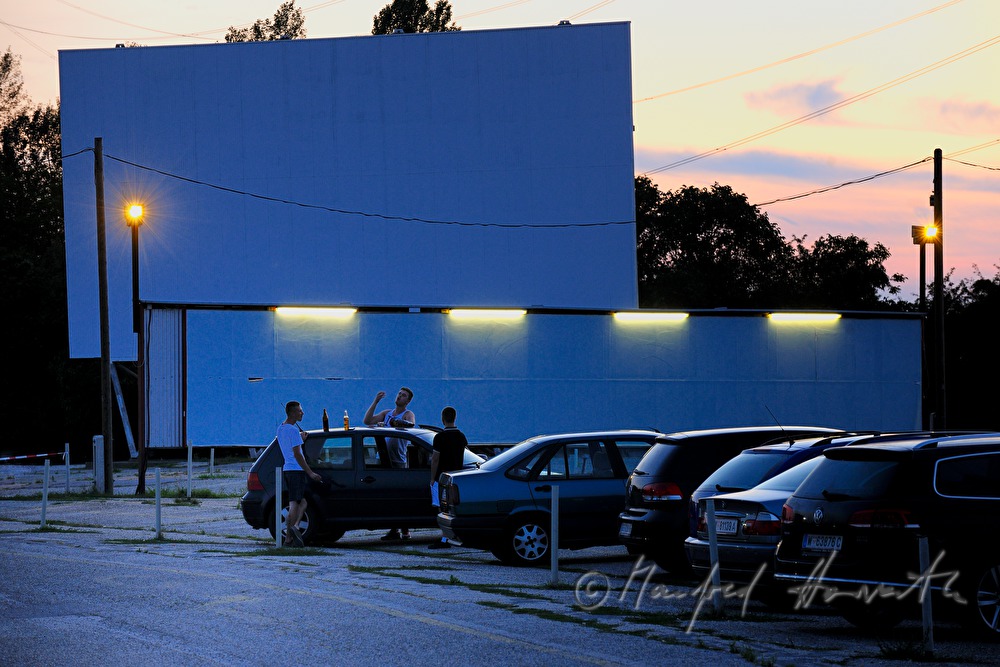 cars with visitors in front of the screen