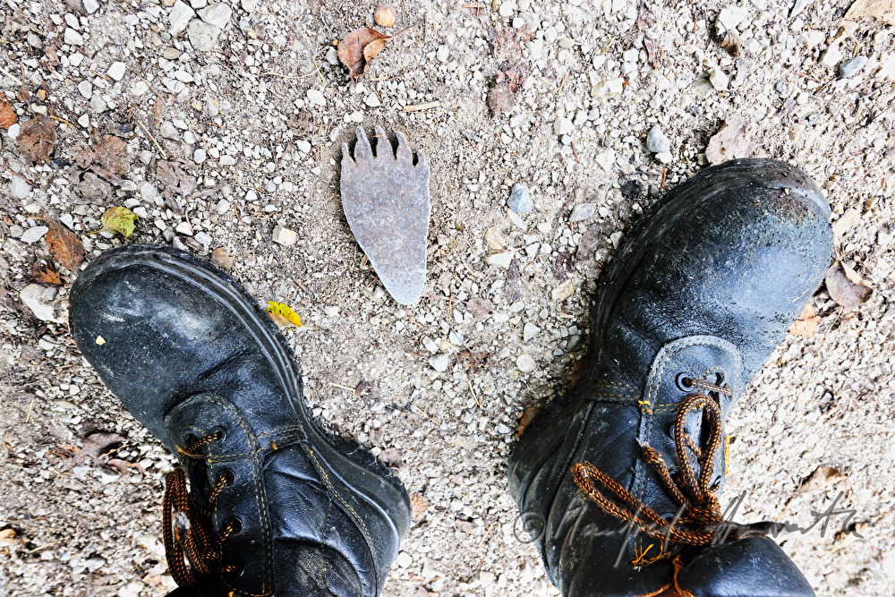 metal foot print of a bear and boots of a hiker