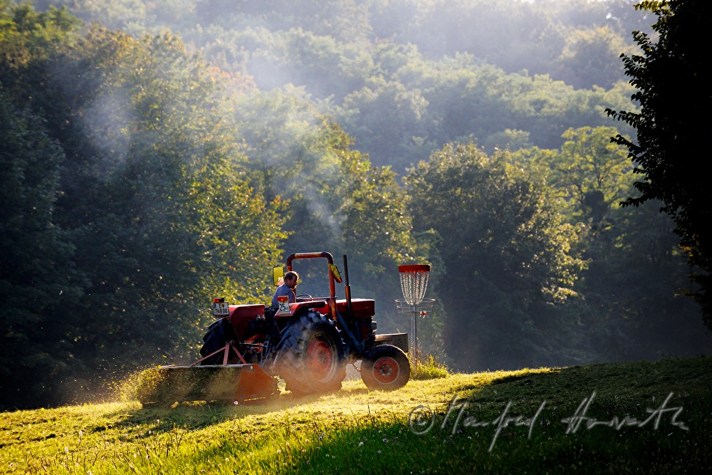farmer mowing the meadow with a mower cutter bar