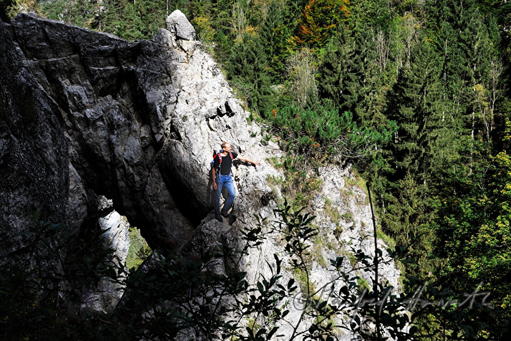 hiker climbing a rock near the Lassingfall