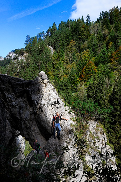 hiker climbing a rock near the Lassingfall