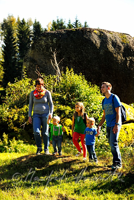 family passes a huge boulder when hiking