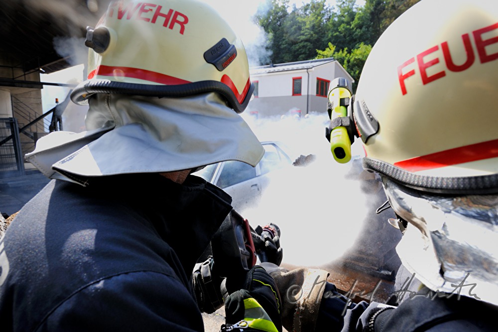 fireman distinguishing a burning car for training