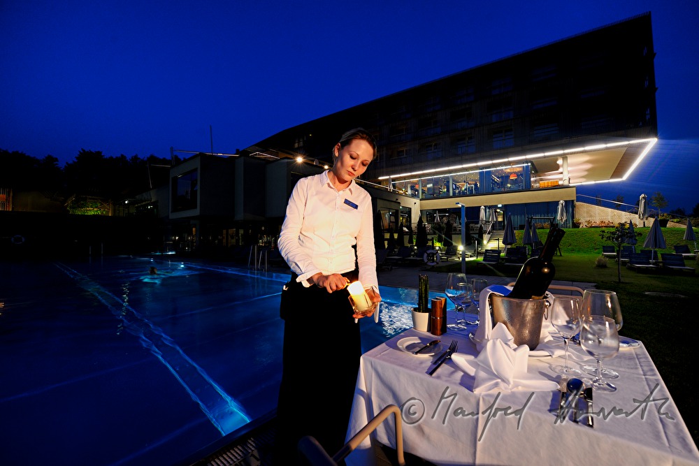 waitress sets the table near the pool