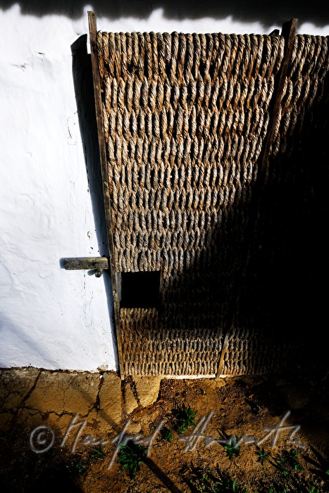 mud-walled wine cellar with thatched roof