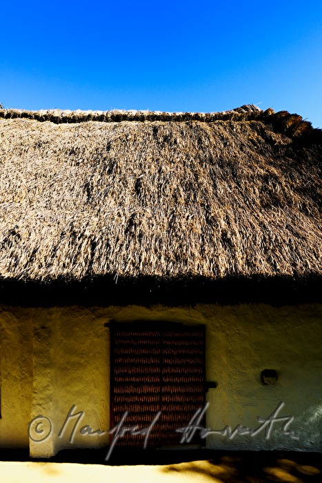 mud-walled wine cellar with thatched roof