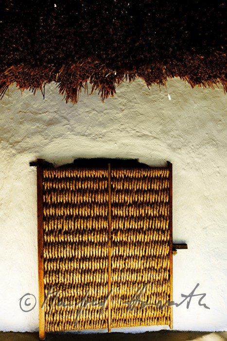 mud-walled wine cellar with thatched roof