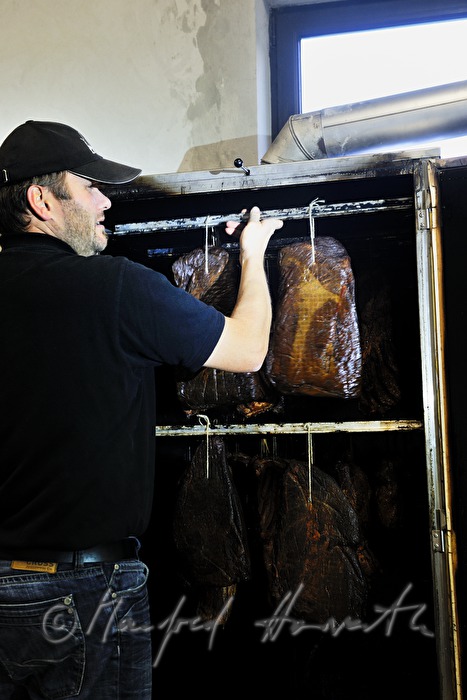 farmer smoking bison ham in the smokebox
