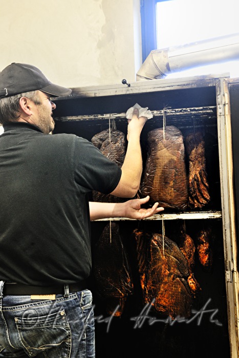 farmer smoking bison ham in the smokebox
