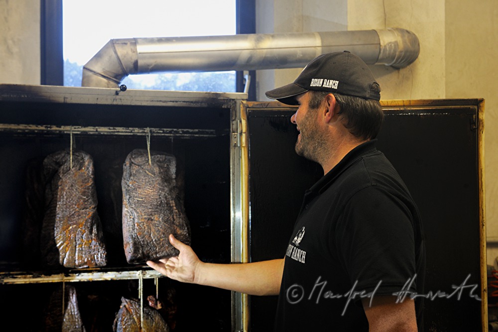 farmer smoking bison ham in the smokebox