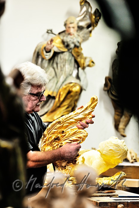 gilder polishing the wing of a baroque angel