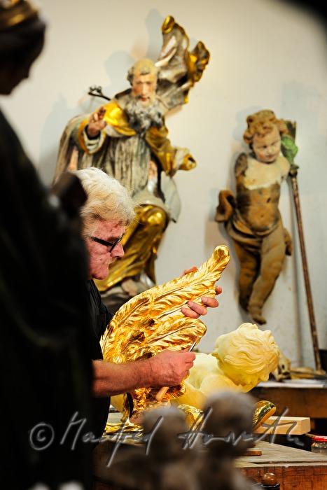 gilder polishing the wing of a baroque angel