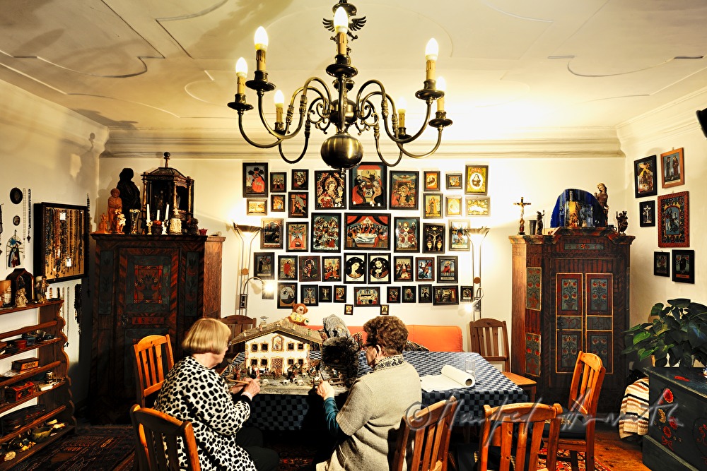 cleaning of a christmas crib in the shape of a Tyrolean farmhouse