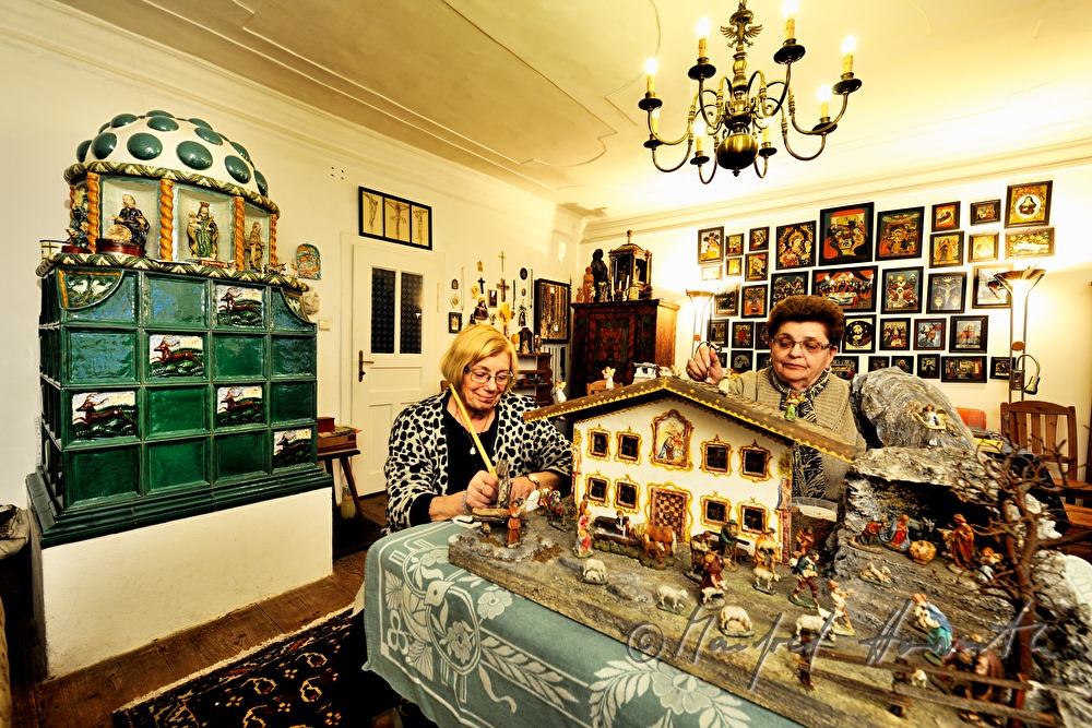 cleaning of a christmas crib in the shape of a Tyrolean farmhouse