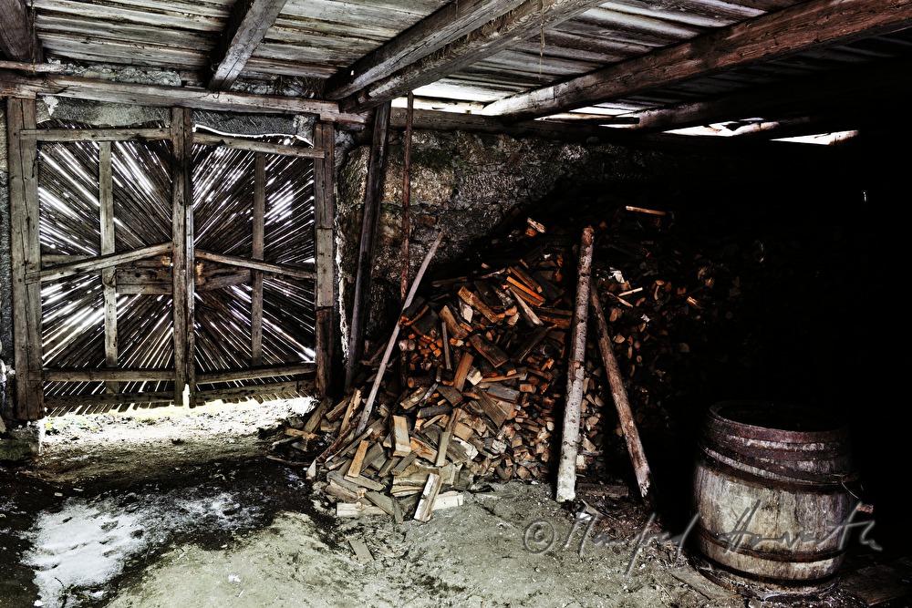 wooden gate of the barn and pile of fire wood
