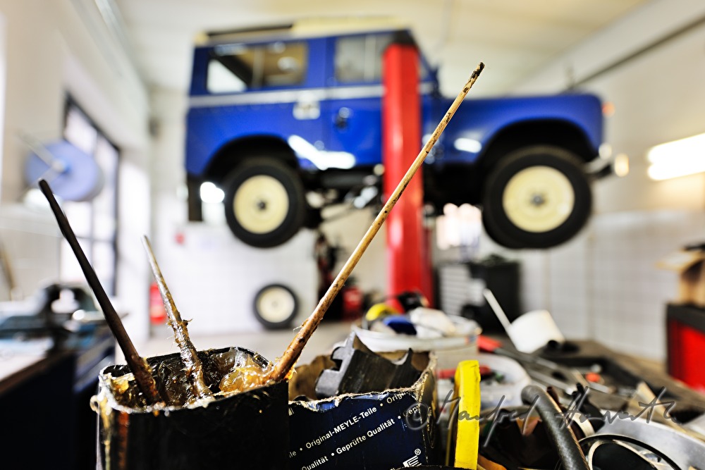 grease in a pot and a Land Rover on the hydraulic ramp