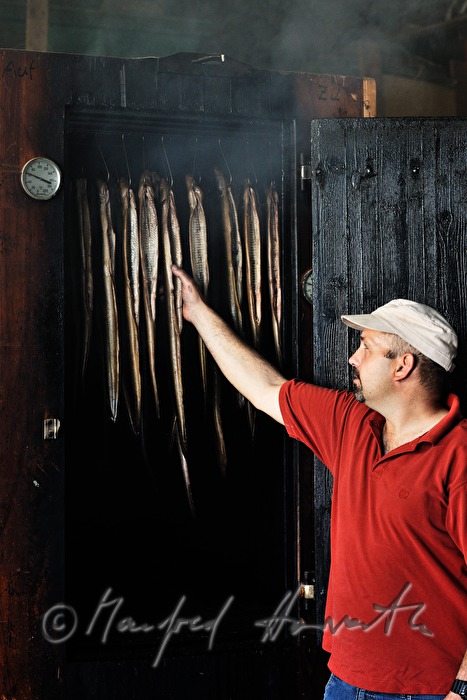 fisherman smokes eels in a smoke chamber