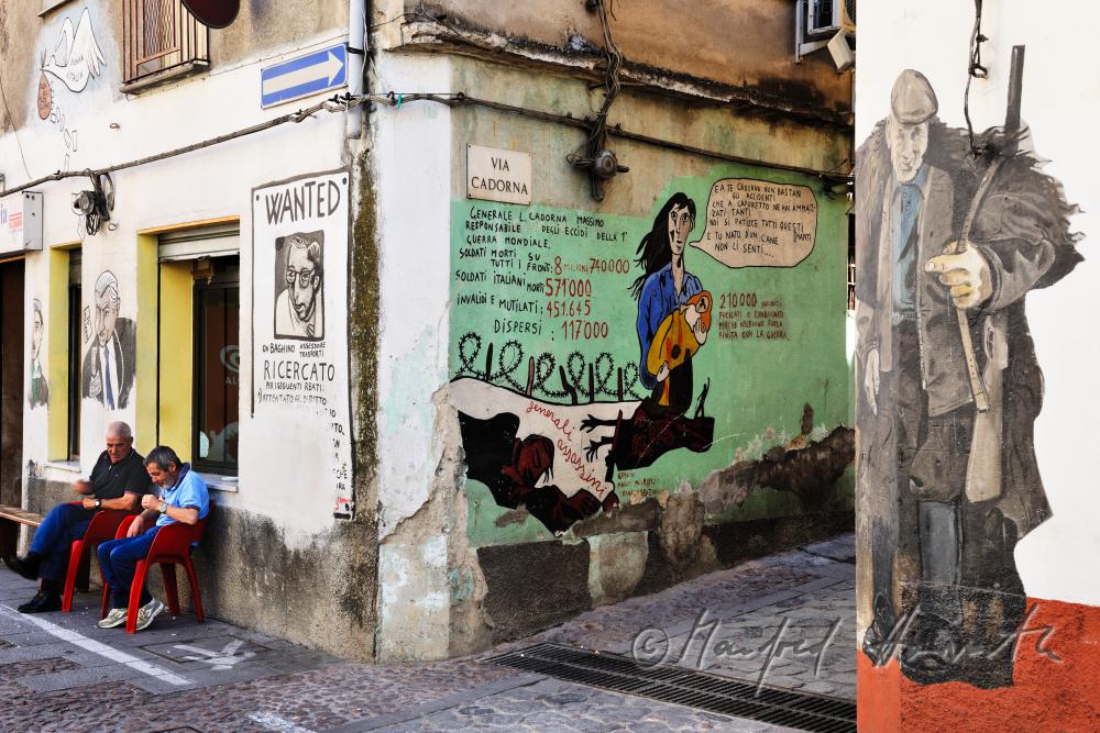 men in a cafe surrounded by mural paintings
