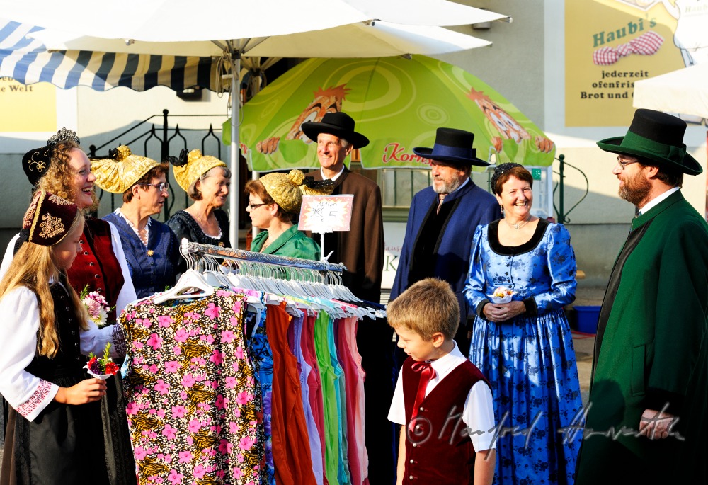 a group of people in traditional dresses at the market