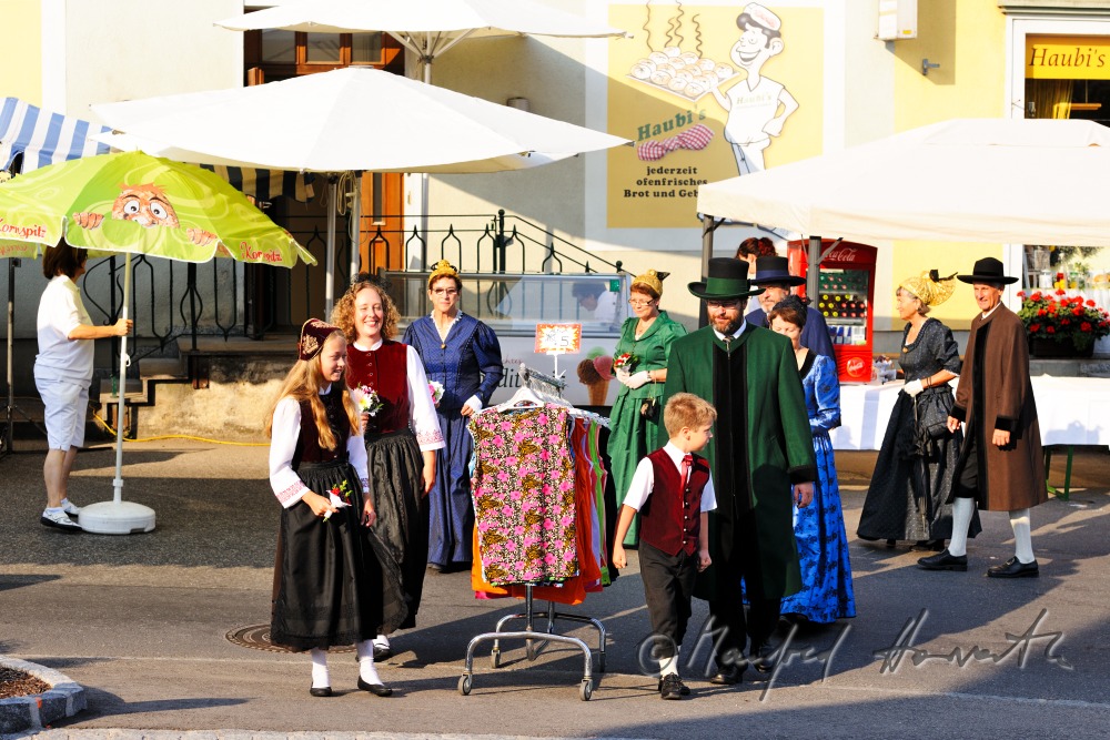 a group of people in traditional dresses at the market