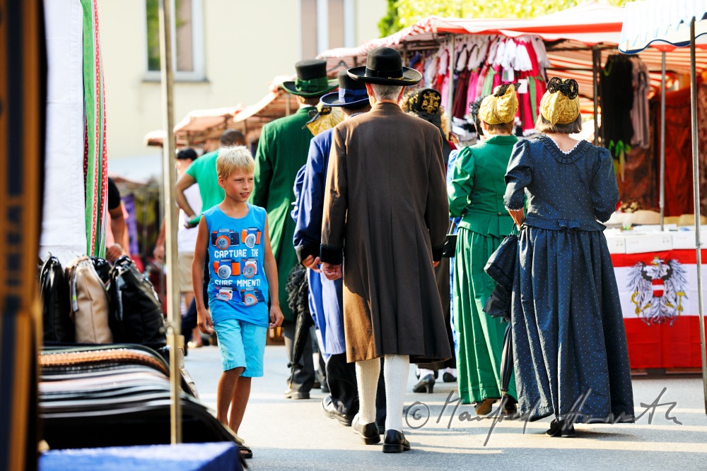 a group of people in traditional dresses at the market
