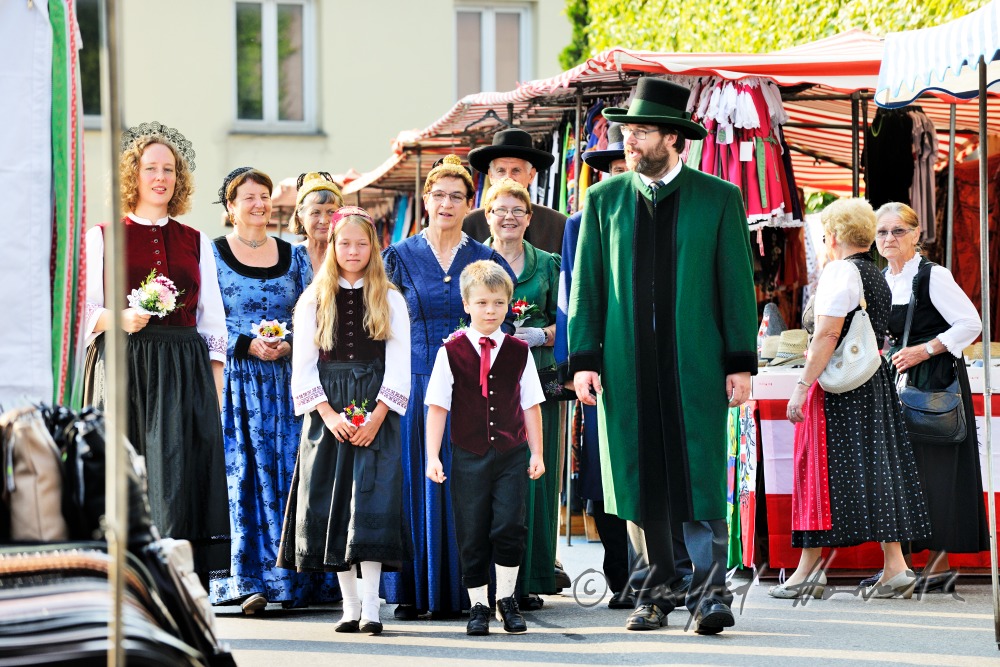 a group of people in traditional dresses at the market