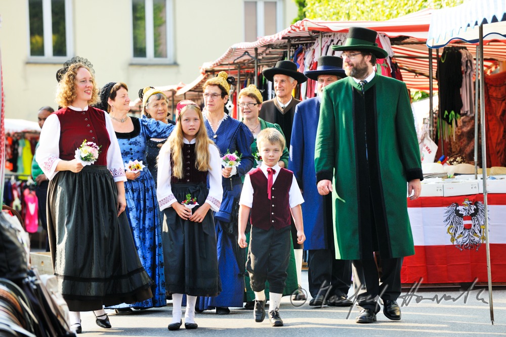 a group of people in traditional dresses at the market