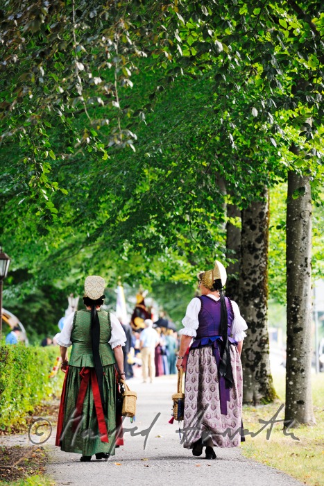 women in traditional clothes on the way to church
