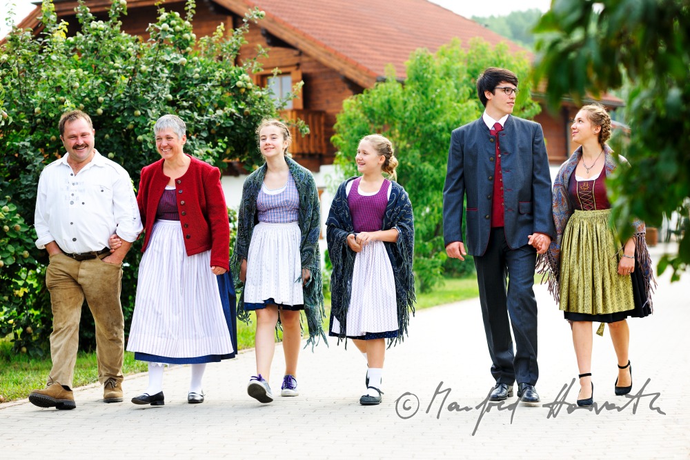 family going to church on Sunday in traditional dresses