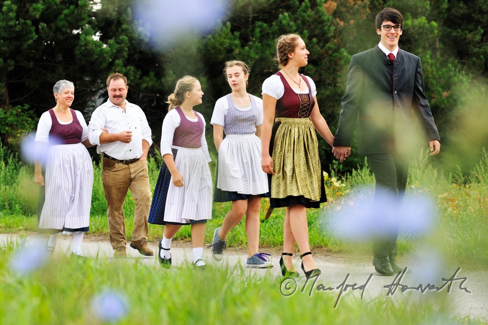 family going to church on Sunday in traditional dresses