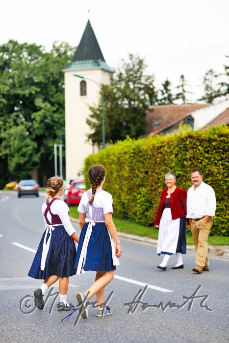 family going to church on Sunday in traditional dresses