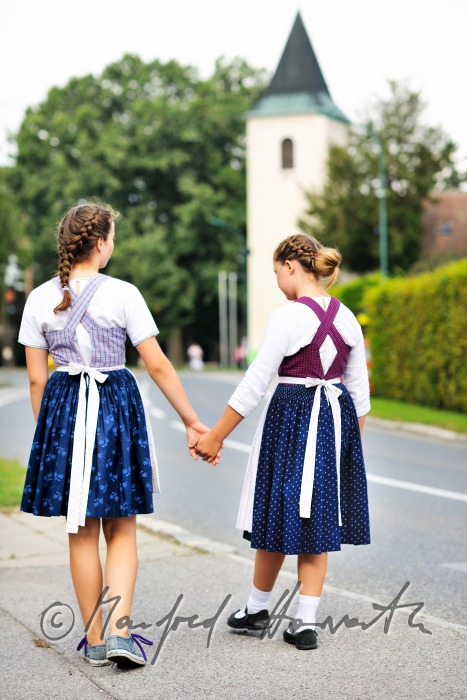 family going to church on Sunday in traditional dresses
