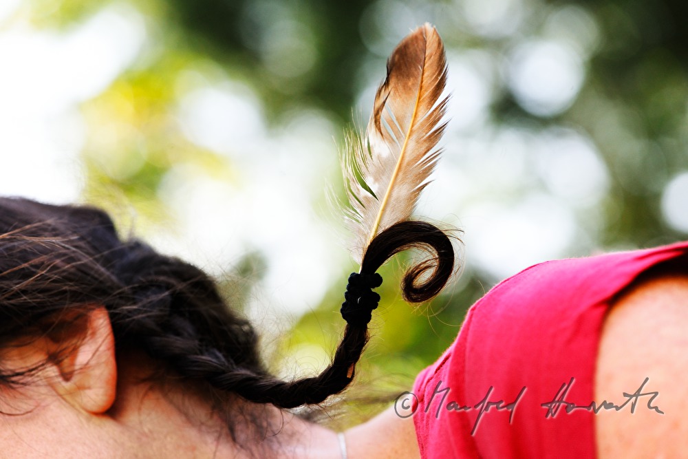 medicine woman with a feather in her braid