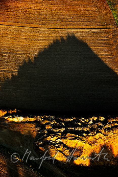 gravel pit near a freshly ploughed field