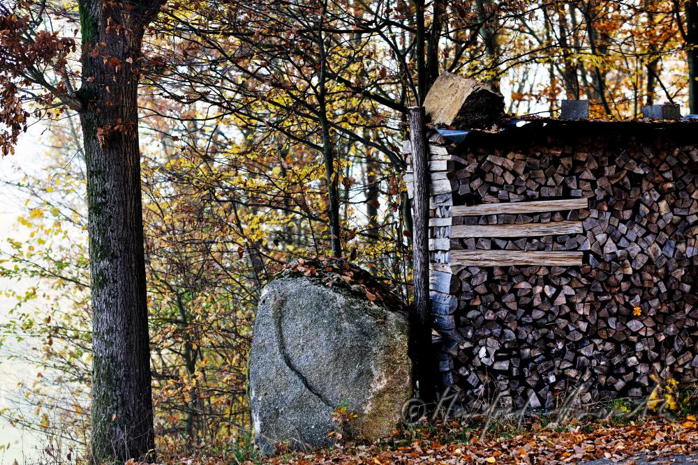 pile of wood with a granite boulder as linchpin
