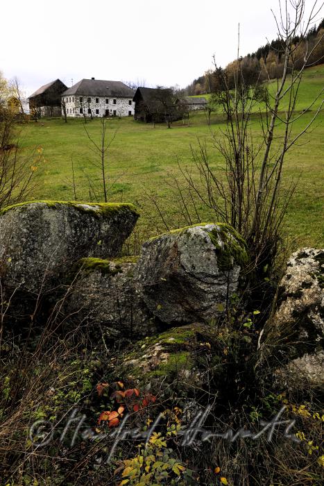 granite boulders in a field near a farm house