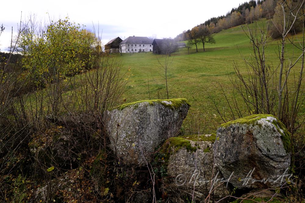 granite boulders in a field near a farm house
