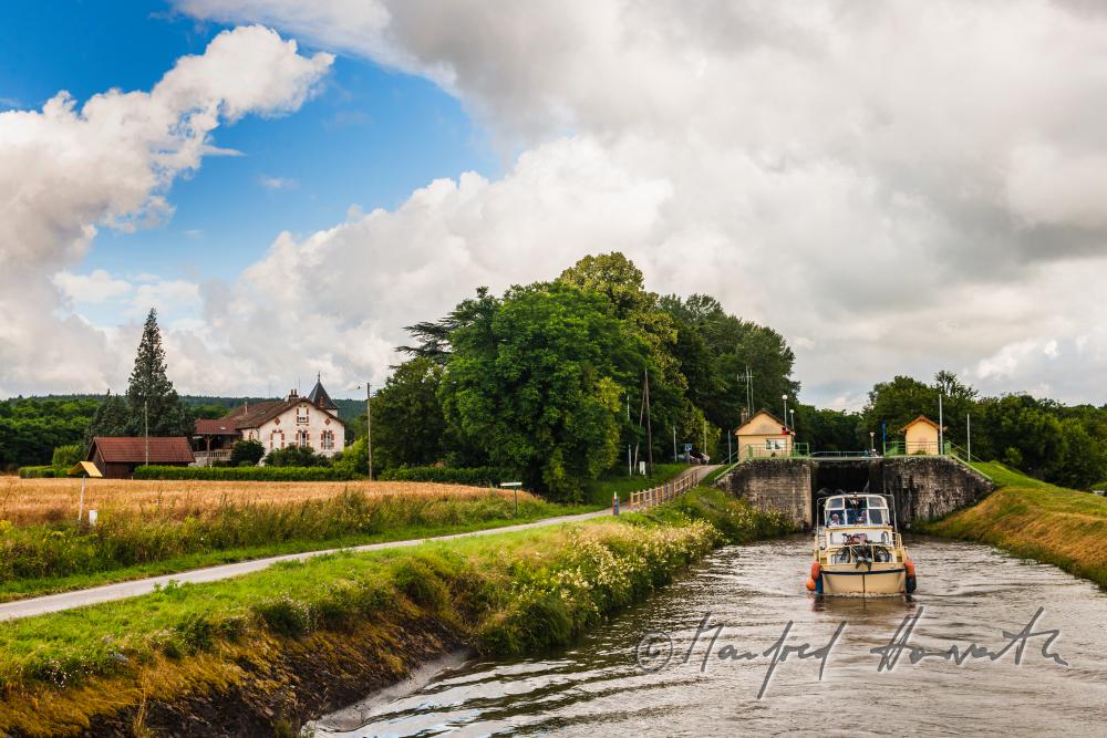 house boat leaving the lock of the town of Rully